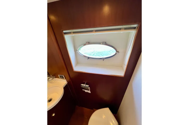  Yacht Photos Pics Bathroom interior of 2010 Princess V78 yacht with porthole window and wooden paneling.