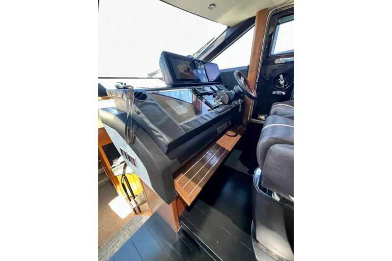  Yacht Photos Pics Interior helm of 2010 Princess V78 yacht with modern controls and leather seating.