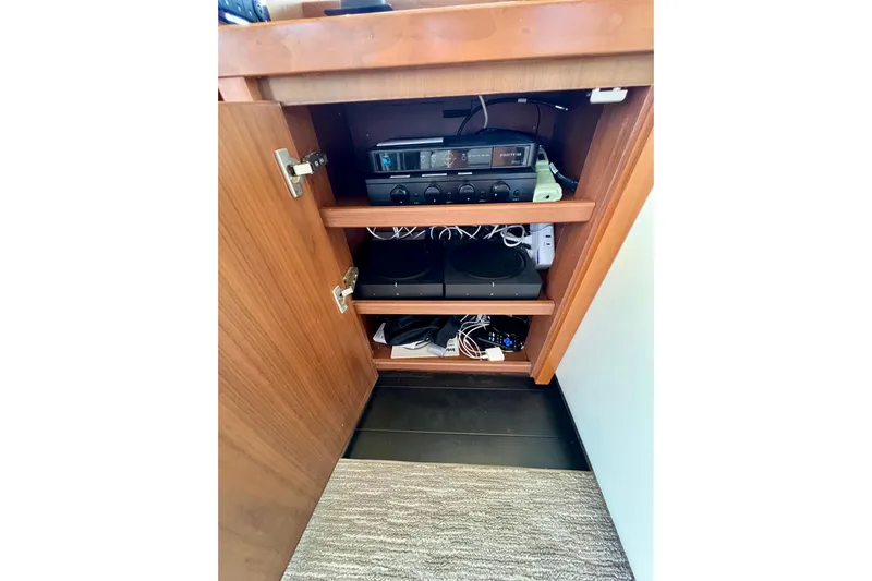  Yacht Photos Pics Open wooden cabinet with electronic equipment and cables inside, on a 2010 Princess V78 yacht.