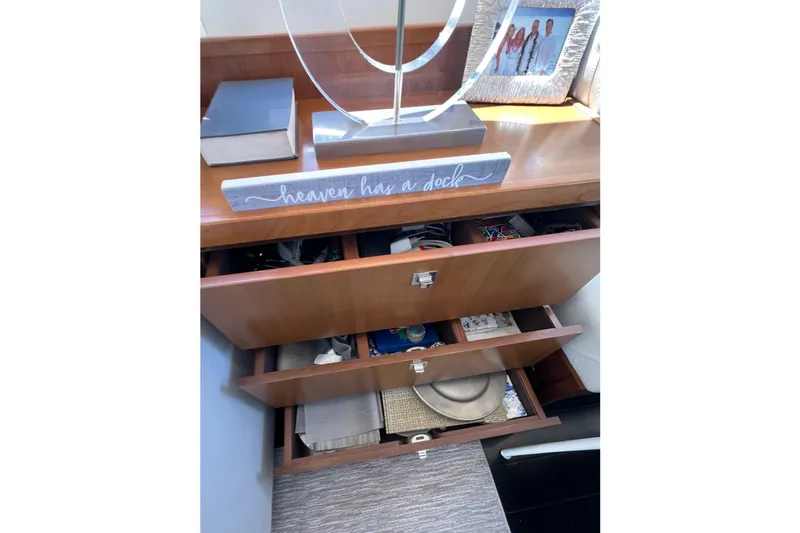  Yacht Photos Pics Wooden cabinet with open drawers, decorative sign, and framed photo on a Princess V78 yacht.