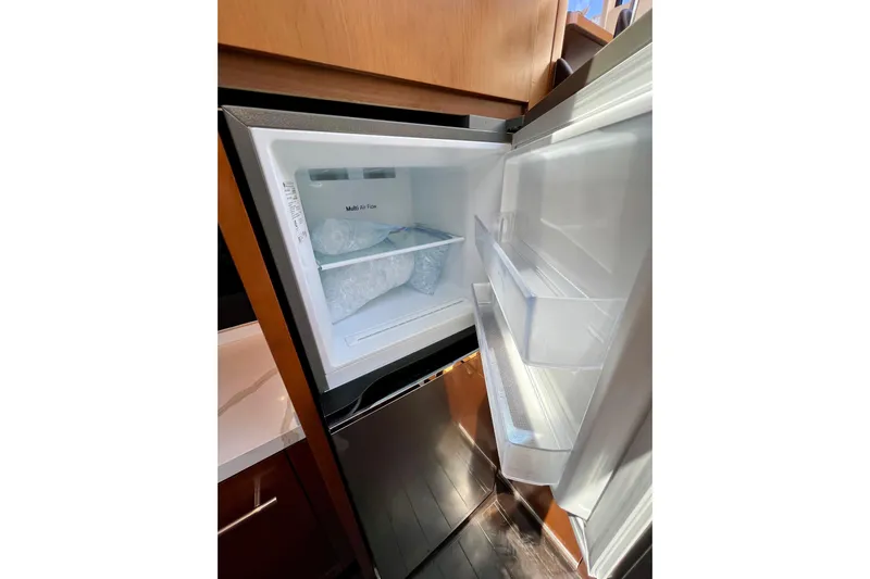  Yacht Photos Pics Open refrigerator in a 2010 Princess V78 yacht, showcasing interior storage and ice compartment.