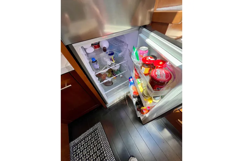  Yacht Photos Pics Open refrigerator on Princess V78 yacht, stocked with various food items and beverages.