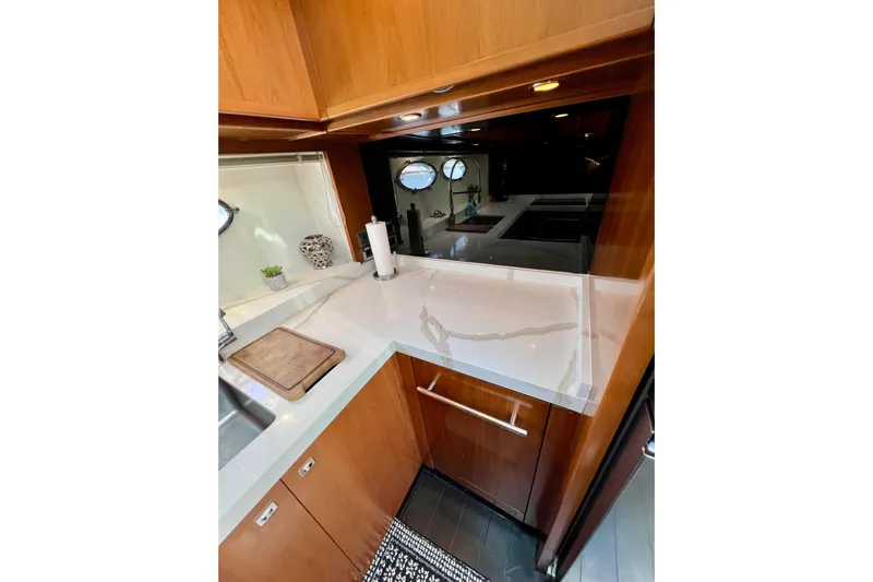  Yacht Photos Pics Luxurious kitchen interior of 2010 Princess V78 yacht with sleek countertops and wooden cabinetry.