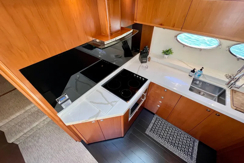  Yacht Photos Pics Luxurious kitchen interior of 2010 Princess V78 yacht with modern appliances and wooden cabinetry.