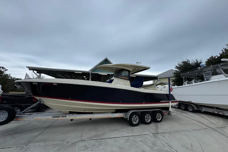  Yacht Photos Pics 2020 Chris-Craft Catalina 30 boat on trailer, parked outdoors under cloudy sky.