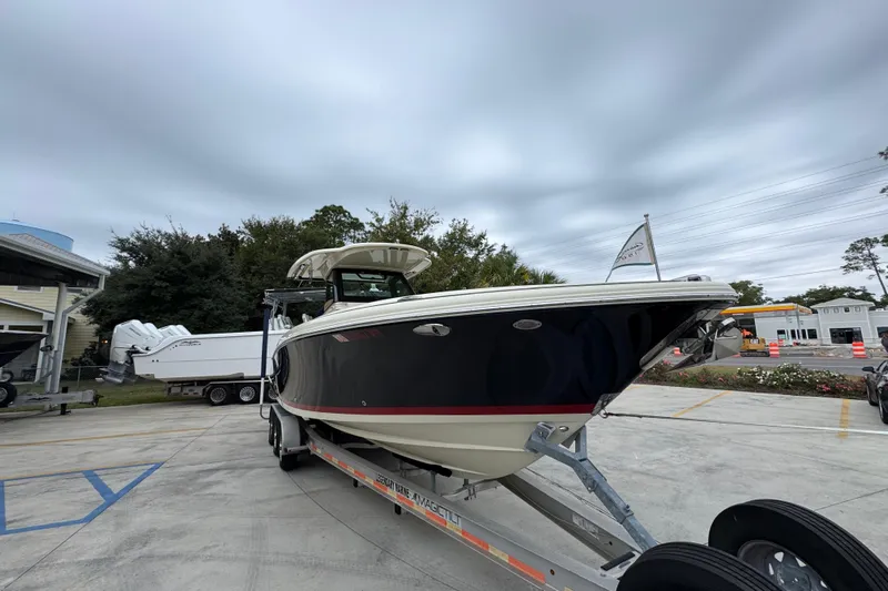  Yacht Photos Pics 2020 Chris-Craft Catalina 30 boat on trailer, parked outdoors under cloudy sky.