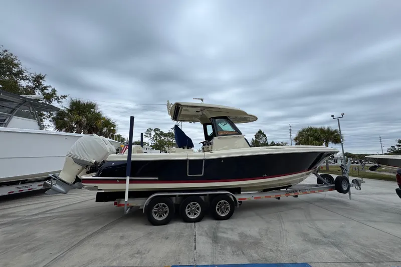  Yacht Photos Pics 2020 Chris-Craft Catalina 30 boat on trailer, parked outdoors under cloudy sky.