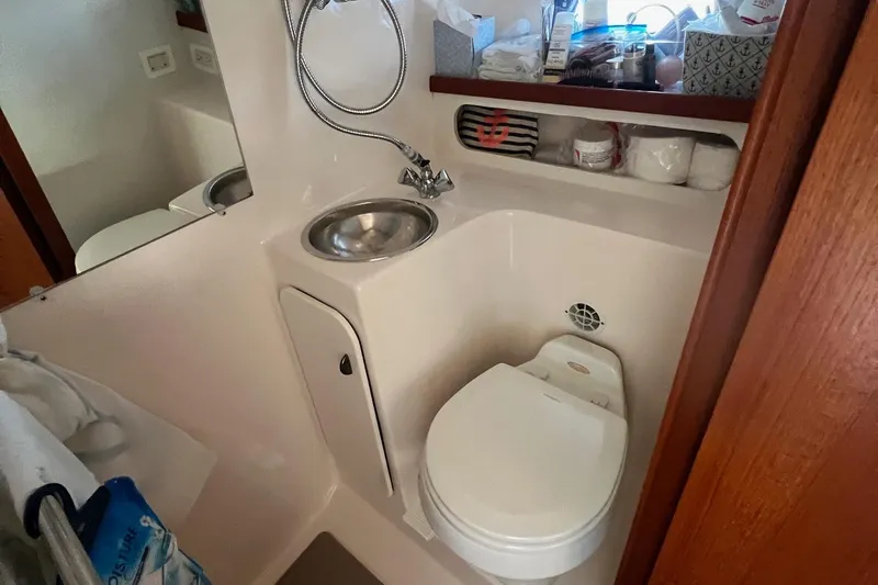  Yacht Photos Pics 2003 Tiara Yachts 3100 Open bathroom with sink, toilet, and storage shelves.