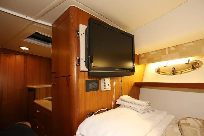 Yacht Photos Pics 2003 Tiara Yachts 3100 Open cabin interior with TV and cozy bedding.