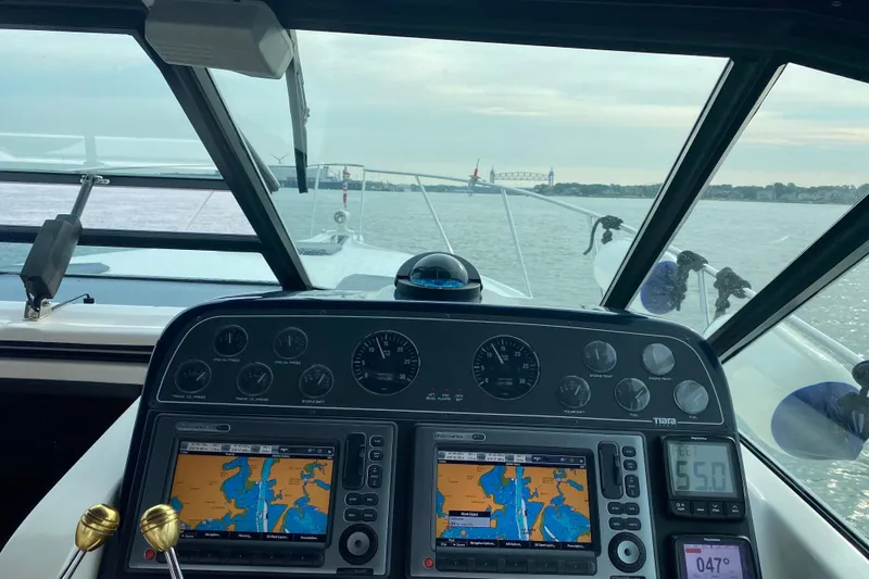  Yacht Photos Pics 2003 Tiara Yachts 3100 Open dashboard with navigation screens and waterway view.