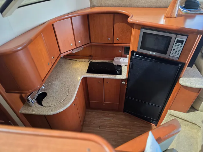 Sanctuary Yacht Photos Pics 2006 Silverton 36 Convertible yacht kitchen with wood cabinets, microwave, and compact appliances.