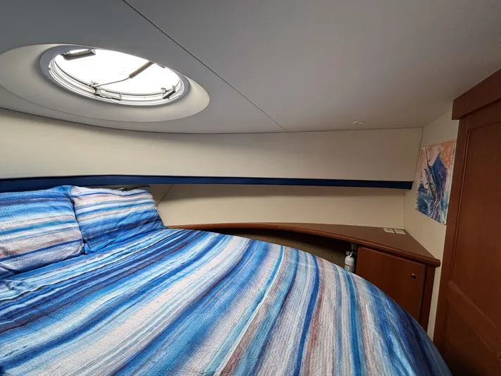 Sanctuary Yacht Photos Pics 2006 Silverton 36 Convertible cabin with striped bedding and porthole window.