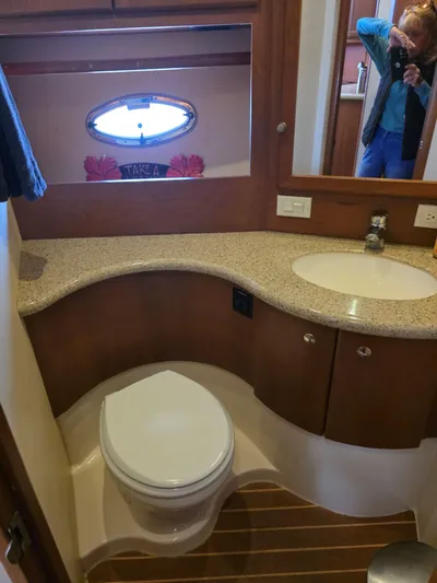 Sanctuary Yacht Photos Pics 2006 Silverton 36 Convertible yacht bathroom with curved countertop and porthole window.