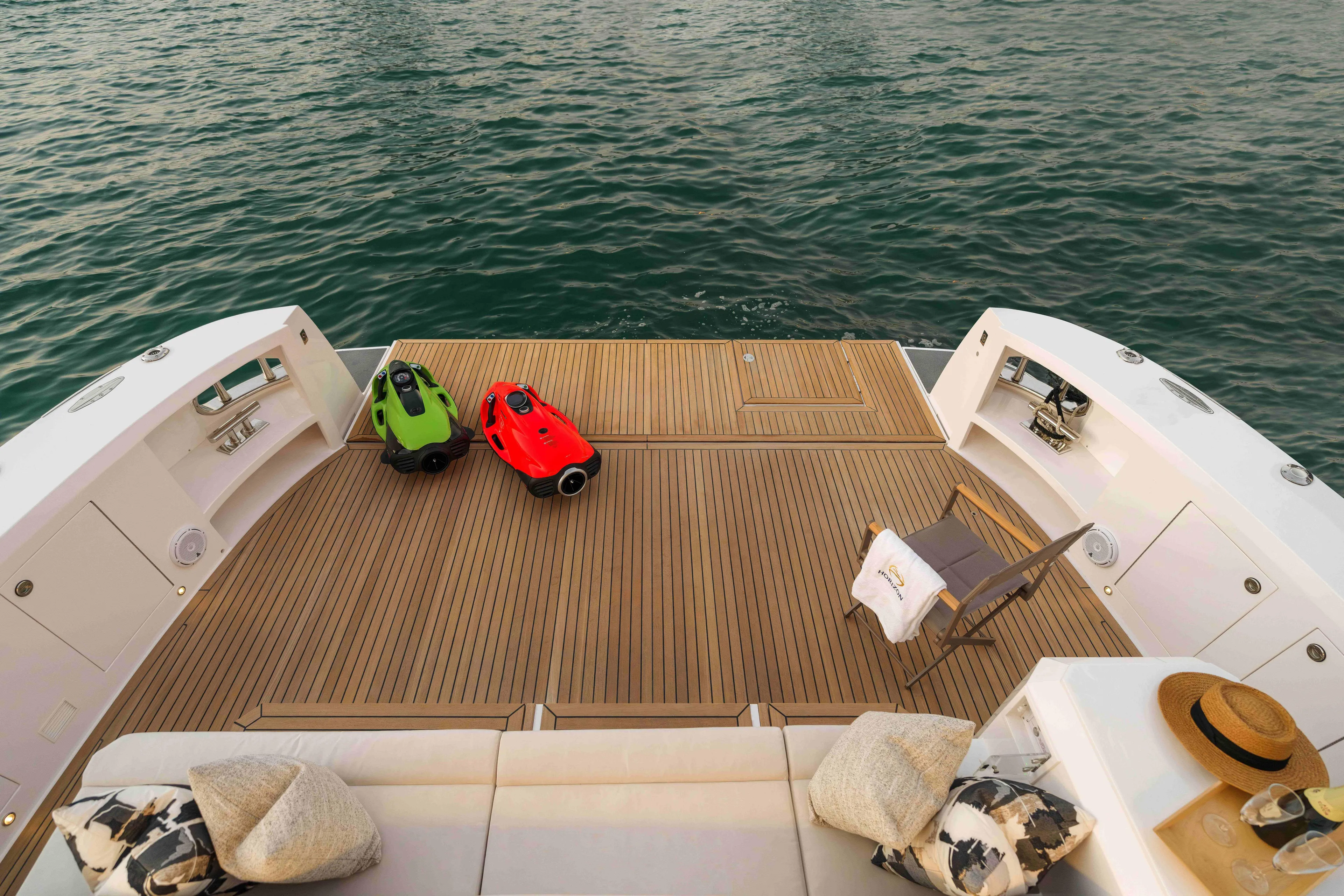 V77s-613 / Available Spring 2026 Yacht Photos Pics Luxury Horizon V77S yacht deck with sea scooters, 2026 model, overlooking calm ocean waters.