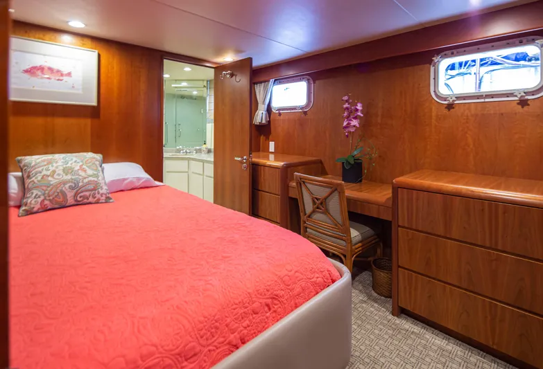Golden Eagle Yacht Photos Pics Luxurious bedroom in 1989 Broward Raised Pilothouse MY yacht with wood paneling and coral bedding.