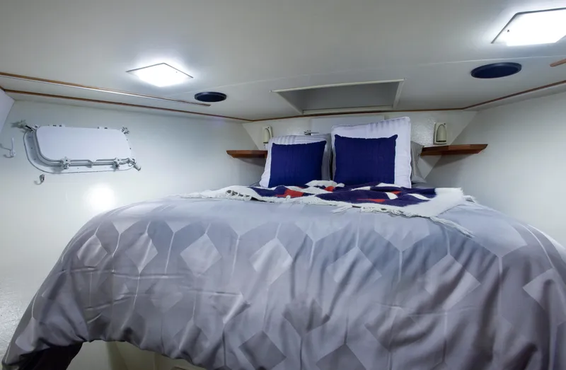 Golden Eagle Yacht Photos Pics Cozy bedroom in 1989 Broward Raised Pilothouse MY yacht with plush bedding and modern lighting.