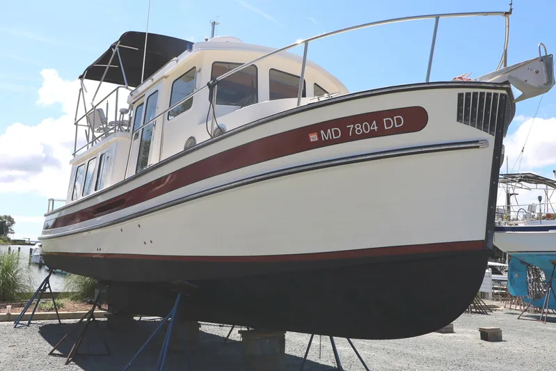 Edgin Yacht Photos Pics 2007 Nordic Tug 32 boat on stands, side view, clear sky background.
