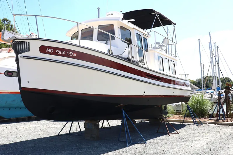 Edgin Yacht Photos Pics 2007 Nordic Tug 32 boat on stands in a marina setting.
