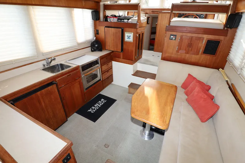 Edgin Yacht Photos Pics Interior of 2007 Nordic Tug 32 with kitchen, seating area, and wooden finishes.