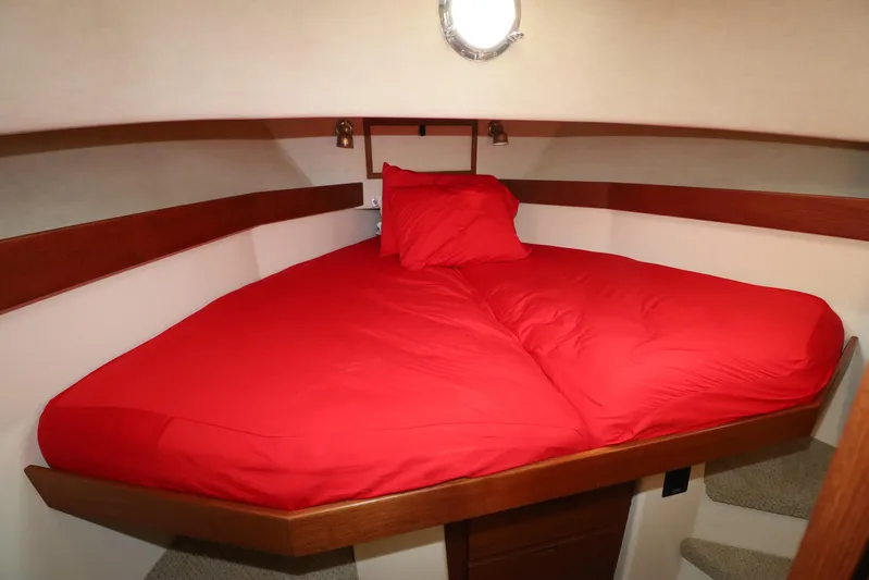 Edgin Yacht Photos Pics Cozy cabin interior of 2007 Nordic Tug 32 with red bedding and wooden accents.
