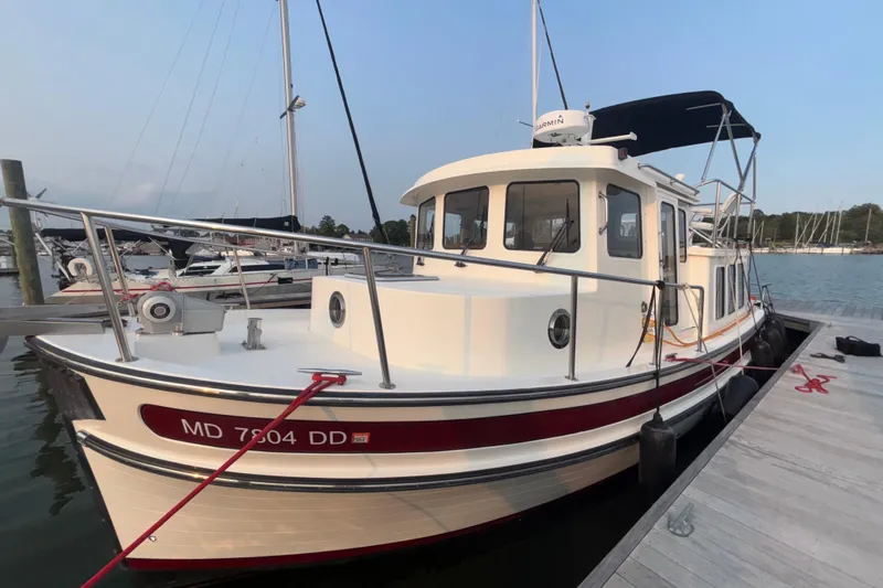Edgin Yacht Photos Pics 2007 Nordic Tug 32 docked at marina, featuring classic design and sturdy build.