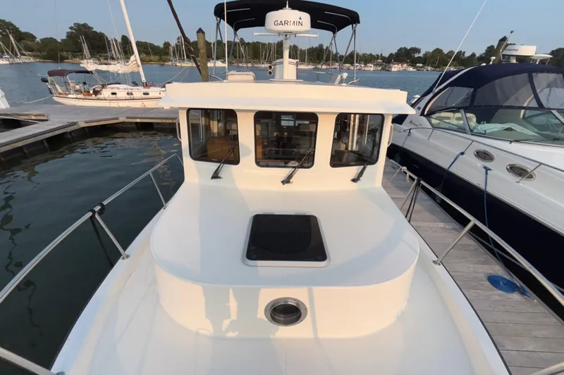 Edgin Yacht Photos Pics 2007 Nordic Tug 32 docked at marina, surrounded by other boats.