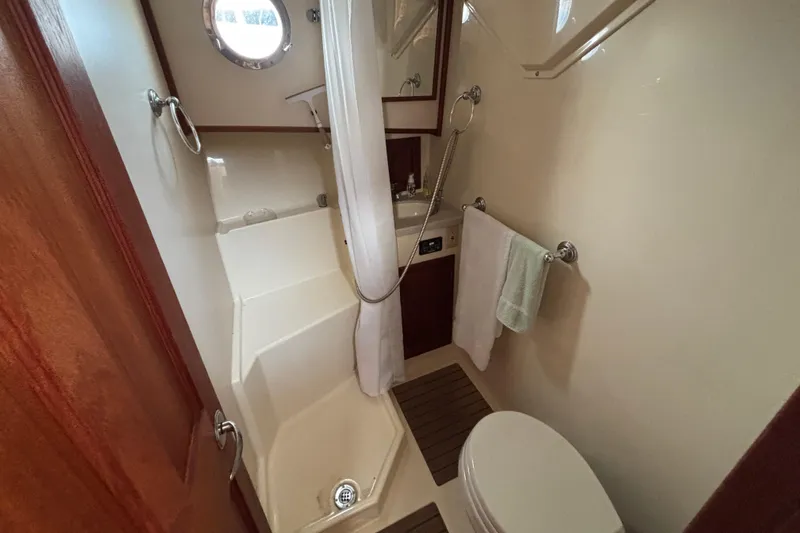 Edgin Yacht Photos Pics Compact bathroom in 2007 Nordic Tug 32, featuring shower, toilet, and porthole window.