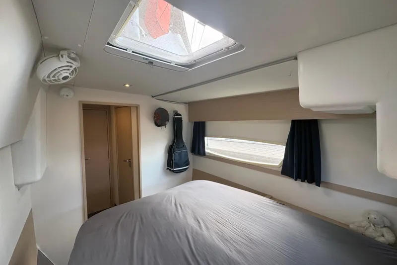 Katla Yacht Photos Pics Interior cabin of 2018 Fountaine Pajot Helia 44 Evolution catamaran, featuring a cozy bed and window.