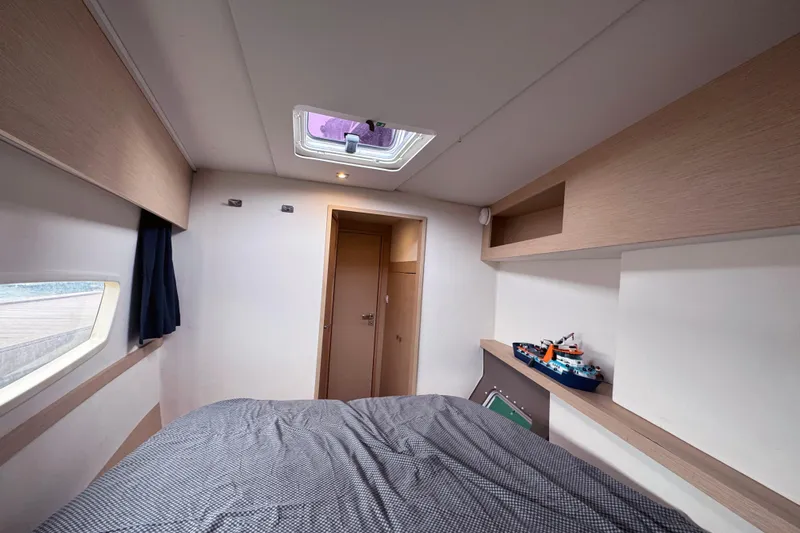 Katla Yacht Photos Pics Cabin interior of 2018 Fountaine Pajot Helia 44 Evolution catamaran, featuring bed and window.