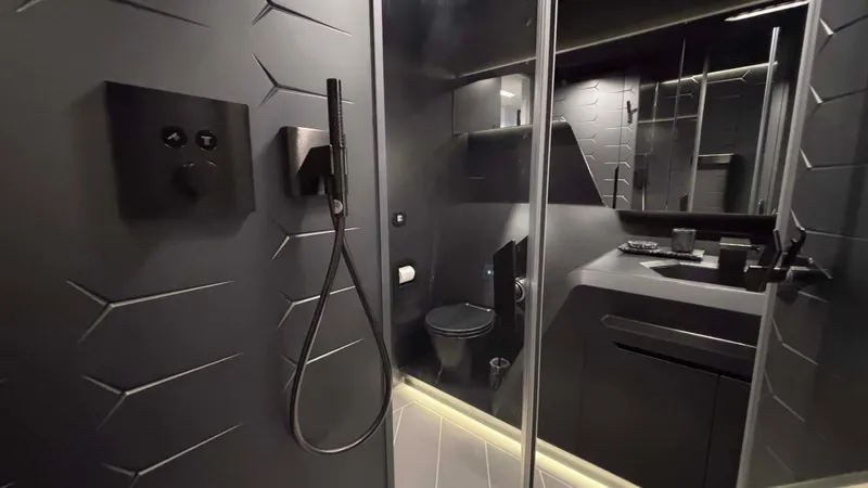  Yacht Photos Pics Luxurious bathroom in 2022 Tecnomar Lamborghini 63 yacht, featuring sleek black design and modern fixtures.