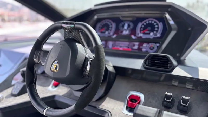  Yacht Photos Pics Interior view of 2022 Tecnomar Lamborghini 63 yacht cockpit with steering wheel and digital dashboard.