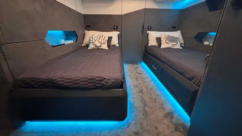  Yacht Photos Pics Luxurious Tecnomar Lamborghini 63 yacht cabin with modern twin beds and ambient blue lighting, 2022 model.