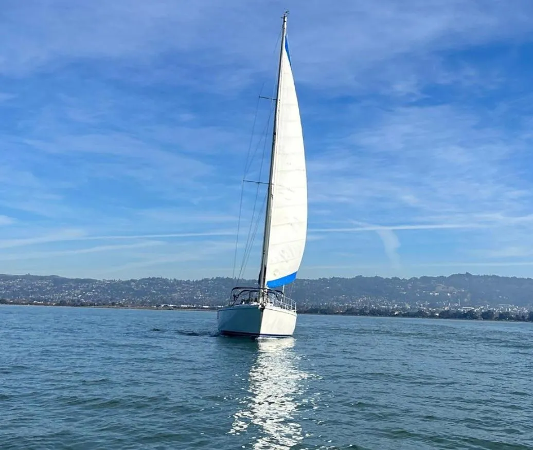 Sailboat Gib'Sea 126 (1985) gliding on calm waters under a clear blue sky.