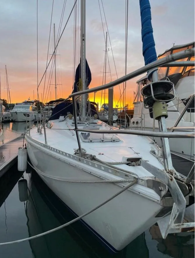 1985 Gib'Sea 126 sailboat docked at sunset, reflecting on calm water.