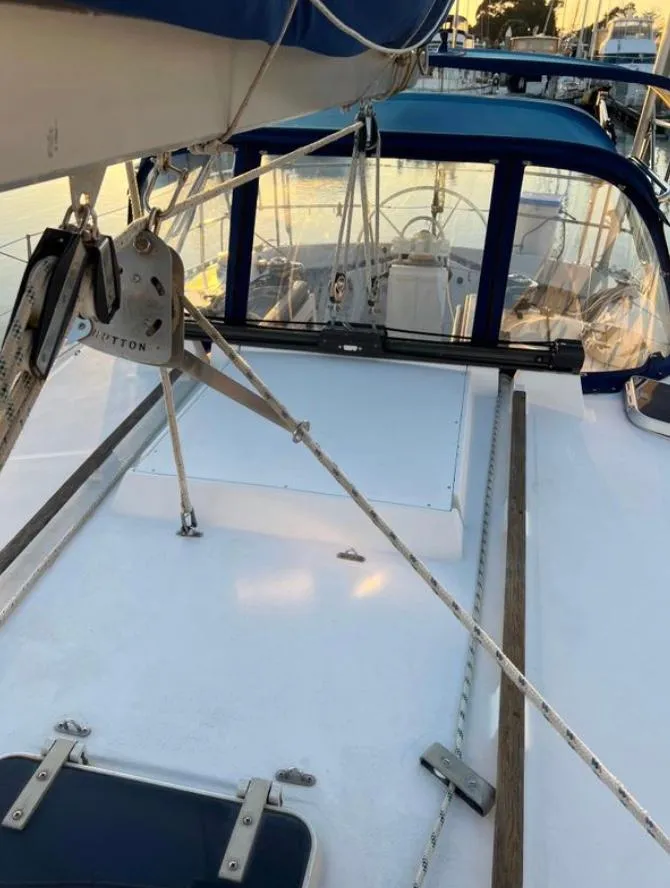 Sailboat deck of 1985 Gib'Sea 126 with rigging and blue canopy in marina.