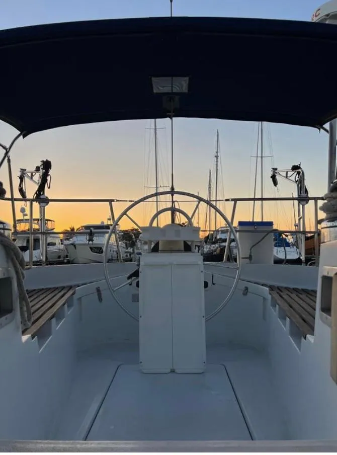Cockpit view of 1985 Gib'Sea 126 sailboat at sunset in marina.