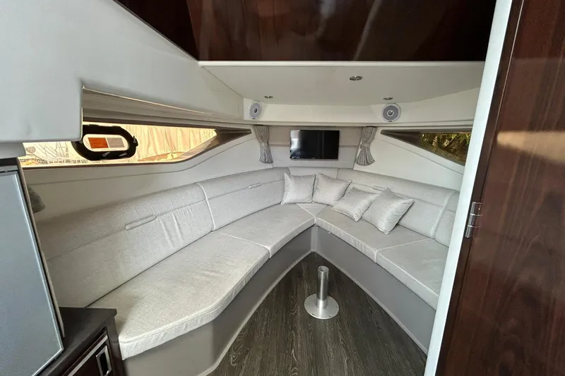  Yacht Photos Pics 2020 Sea Ray Sundancer 320 interior with curved seating, TV, and modern decor.