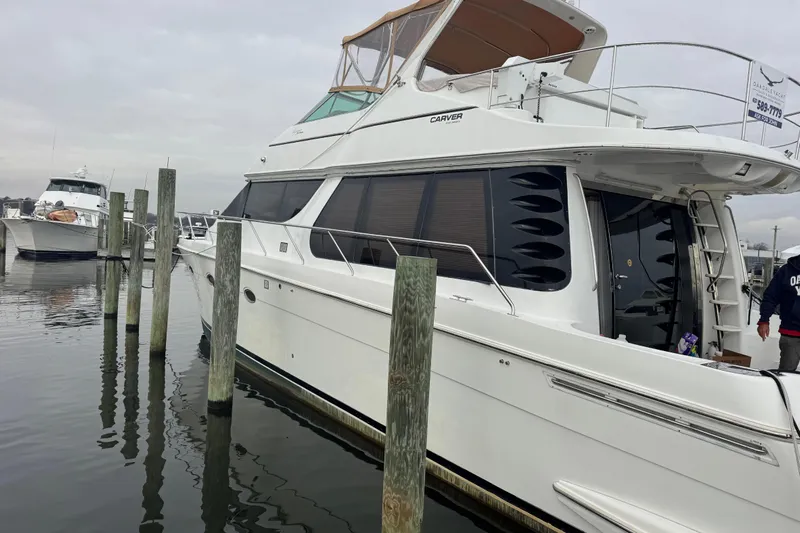 Size Matter's Yacht Photos Pics 2001 Carver 530 Voyager Pilothouse yacht docked at marina, side view.
