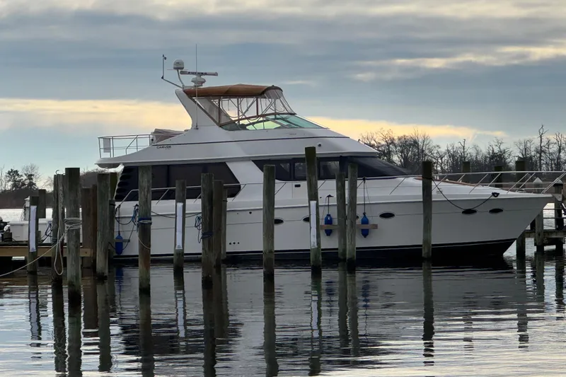 Size Matter's Yacht Photos Pics 2001 Carver 530 Voyager Pilothouse yacht docked at marina under cloudy sky.