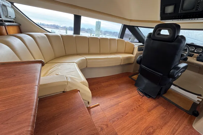 Size Matter's Yacht Photos Pics Pilothouse interior of 2001 Carver 530 Voyager with leather seating and wood flooring.