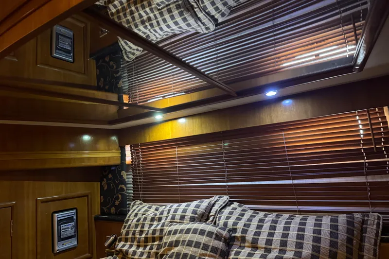 Size Matter's Yacht Photos Pics Interior of 2001 Carver 530 Voyager Pilothouse with wooden blinds and checkered cushions.