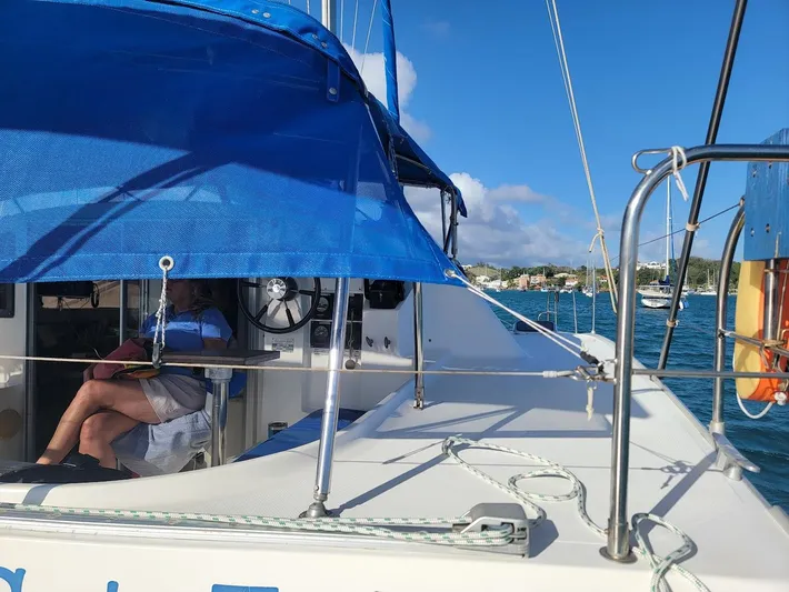 Cat Tales Yacht Photos Pics 1996 Fountaine Pajot Tobago 35 catamaran with blue canopy, sailing on a sunny day.