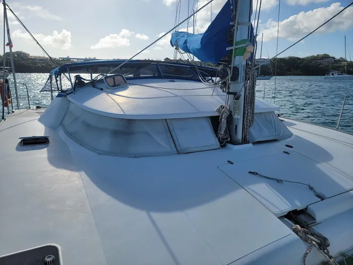 Cat Tales Yacht Photos Pics 1996 Fountaine Pajot Tobago 35 catamaran on water, featuring sleek design and blue sail.