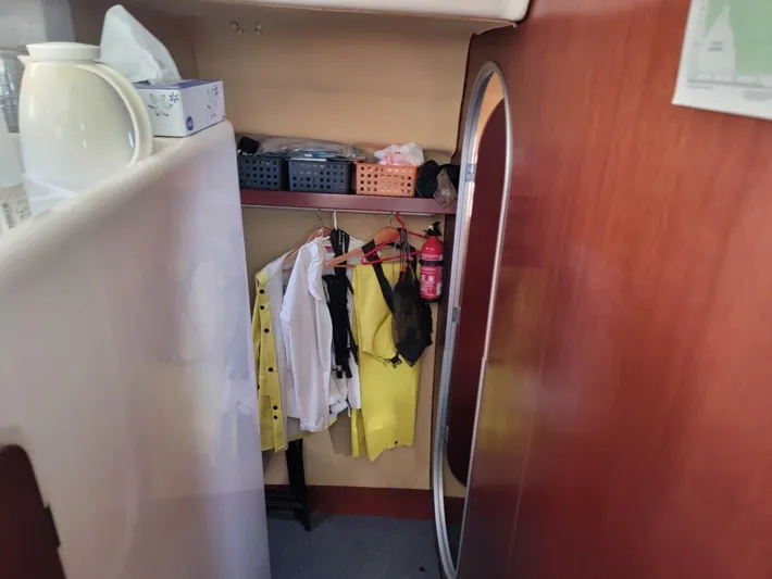 Cat Tales Yacht Photos Pics Interior of 1996 Fountaine Pajot Tobago 35 with clothes hanging and storage shelves.