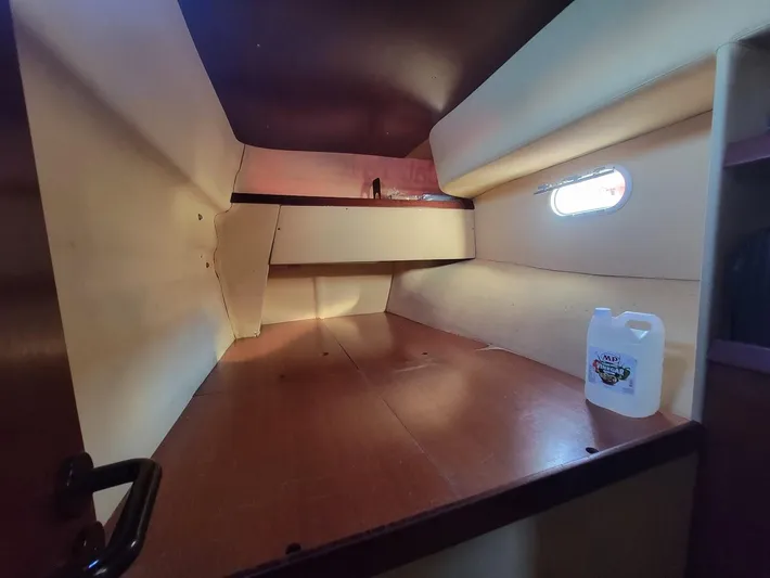 Cat Tales Yacht Photos Pics Interior cabin of 1996 Fountaine Pajot Tobago 35 catamaran, featuring a small window and storage space.