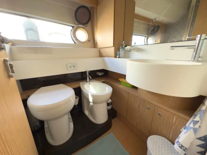  Yacht Photos Pics Luxurious bathroom in a 2011 Ferretti Yachts 570, featuring modern fixtures and wood cabinetry.