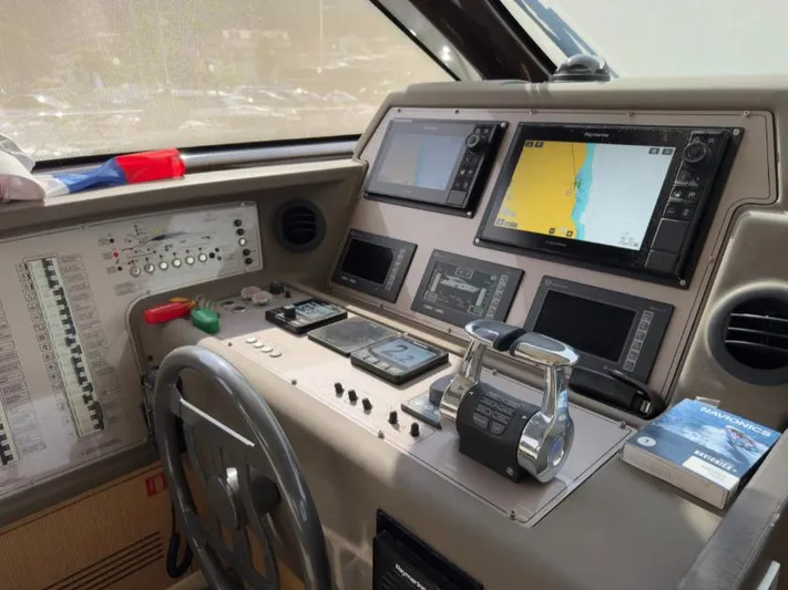  Yacht Photos Pics Control panel of a 2011 Ferretti Yachts 570 with navigation screens and controls.