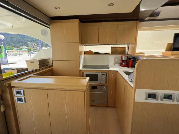 Yacht Photos Pics Modern kitchen interior on 2011 Ferretti Yachts 570, featuring wood cabinetry and appliances.