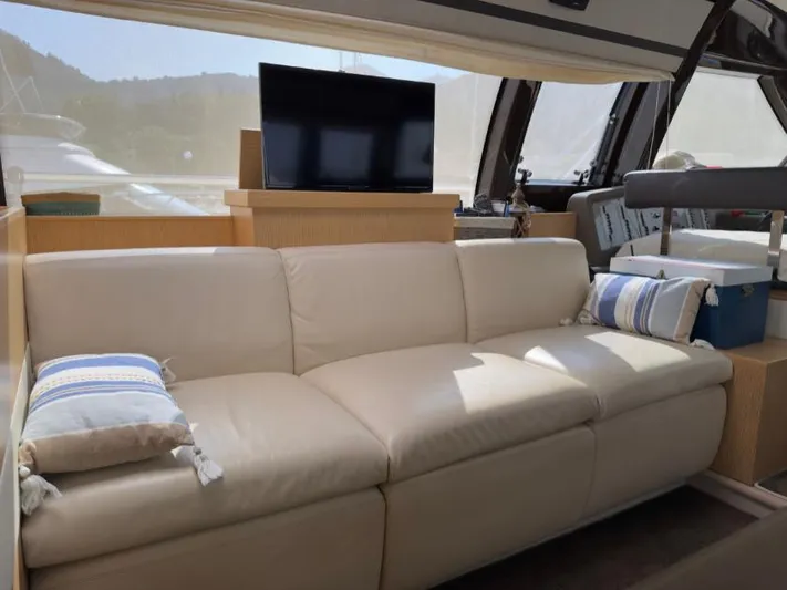  Yacht Photos Pics Luxurious interior of 2011 Ferretti Yachts 570 with beige sofa and TV.