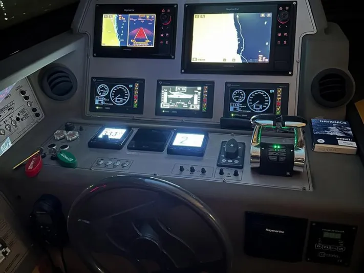  Yacht Photos Pics Control panel of a 2011 Ferretti Yachts 570 with navigation screens and controls.